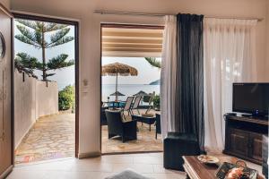 a living room with a view of the ocean at Villa Andriana & Villa Elena - Beachfront Pool Villas in Vasilikos