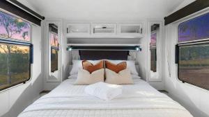 a bed in the back of an rv with windows at Vineyard Farmstay in Clare