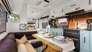 a living room with a couch and a table in a rv at Vineyard Farmstay in Clare