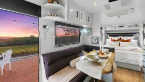 a bedroom and a living room in a rv at Vineyard Farmstay in Clare
