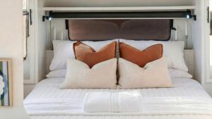 a white bed with two pillows on it at Vineyard Farmstay in Clare +10 photos