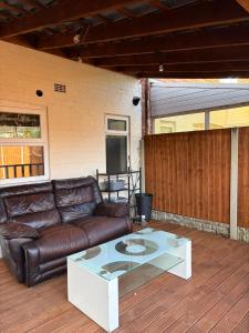 a living room with a leather couch and a coffee table at Jerry's lane 3 bed house free parking free wifi in Birmingham
