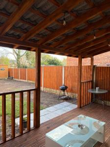 a wooden pergola with a table on a deck at Jerry's lane 3 bed house free parking free wifi in Birmingham