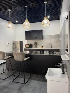 a kitchen with two bar stools and a sink at Twenty ritz in Migori