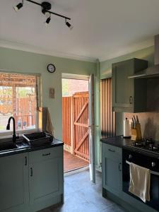 a kitchen with an open door to a deck at Jerry's lane 3 bed house free parking free wifi in Birmingham