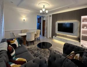 a living room with a couch and a tv at Home Soft in Douala