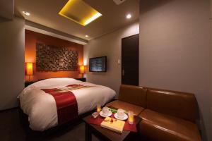 een hotelkamer met een bed en een bank bij Hotel COREST (Adult Only) in Tokyo