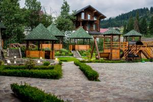 a log cabin with a playground and a house at Lavina Hotel in Bukovel