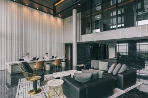 a lobby with two people working at desks in a building at The Outpost Hotel Sentosa by Far East Hospitality in Singapore