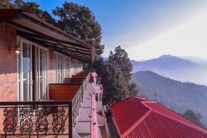 a building with a balcony with a view of the mountains at Blue Pine Resort in Lansdowne
