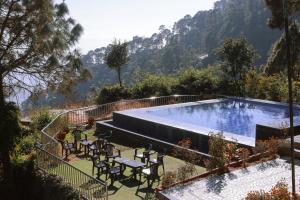 a swimming pool with tables and chairs and a mountain at Blue Pine Resort in Lansdowne