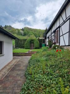 a house with a brick walkway next to a yard at Wunderschöne Ferienwohnung in Thüringen in Langenorla