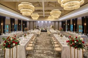 a banquet hall with white tables and chairs with red flowers at The Outpost Hotel Sentosa by Far East Hospitality in Singapore +32 photos
