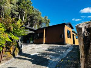 a house with a driveway in front of it at The Cozy Cottage-With elevated views in Queenstown