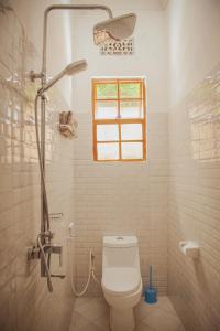 a bathroom with a toilet and a shower with a window at Makinihomestay in Arusha +26 photos