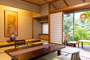 a dining room with a table and a window at Yoshiike Ryokan in Hakone
