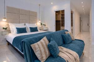 a bedroom with a large bed and a blue couch at Luxury Maubourg - Vue mer - Croisette 50m plage - Clim - terrasse in Cannes +12 photos