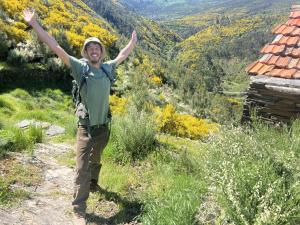 a man standing on a mountain with his arms in the air at Quinta WOW in Benfeita +12 photos