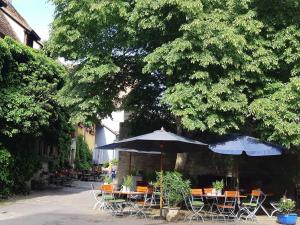 a patio with tables and chairs with umbrellas at Altfraenkische Weinstube in Rothenburg ob der Tauber