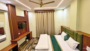 a hotel room with a bed and a tv at The Gripa Hotels in Chitrakoot