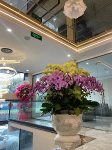 a vase filled with flowers on a table in a store at Coline Hotel & Aparment in Ninh Binh