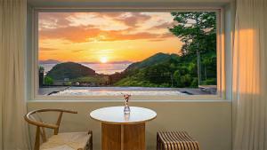 a window with a view of a sunset at Namhae U9Stay in Namhae