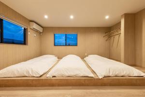 a bedroom with two beds and a window at The Bear ベアSpacious Holiday Villa in Inzai