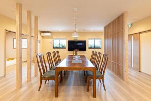 a dining room with a wooden table and chairs at The Bear ベアSpacious Holiday Villa in Inzai
