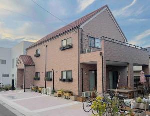 a large brick building with a table and a bike at The Bear ベアSpacious Holiday Villa in Inzai