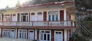 a house with a balcony on the side of it at Alavyahomestay in Kilba