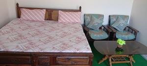 a bed with two pillows and a table with a glass table at Alavyahomestay in Kilba