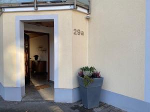 a building with two potted plants on the side of it at Ferienwohnung am Breitenbach in Ebermannstadt