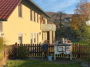 a house with a stove in front of a fence at Ferienwohnung am Breitenbach in Ebermannstadt