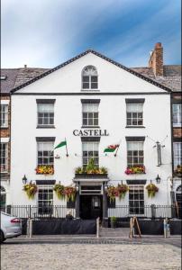 a large building with a clock on the front of it at Y Castell in Caernarfon