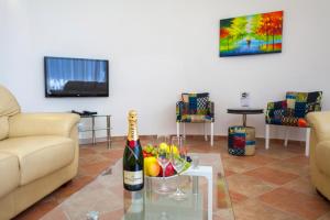 uma sala de estar com uma garrafa de champanhe e fruta numa mesa em Royal Villas em Dobra Voda