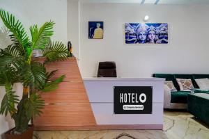 a hotel reception desk in a room with a plant at OYO Hotel O Ayodhya Dham Bus Terminal Formerly Om Palace in Ayodhya