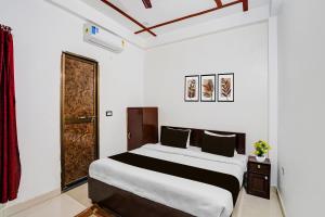 a bedroom with a large bed and a door at OYO Hotel O Ayodhya Dham Bus Terminal Formerly Om Palace in Ayodhya
