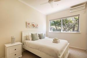 a white bedroom with a bed and a window at Meelup Vista in Dunsborough +22 photos