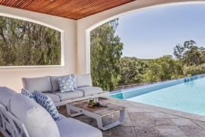 an outdoor living room with a swimming pool and a table at Meelup Vista in Dunsborough