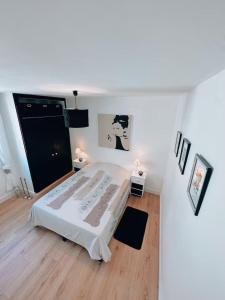 a white room with a bed and some pictures at Duplex de Charme en Provence, Vue Imprenable in Bargemon