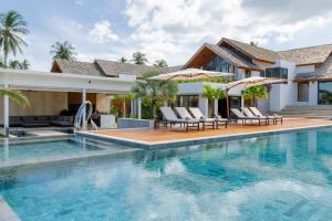 a villa with a swimming pool and a house at Masima Samui Villa in Koh Samui