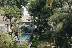 a house with a swimming pool in a garden at Sanglung Villas & Suites in Kubutambahan