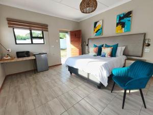 a bedroom with a bed and a blue chair at Nu Oasis guest house in Johannesburg