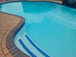 a large swimming pool with blue water at Nu Oasis guest house in Johannesburg