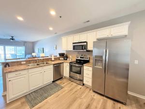 a kitchen with white cabinets and stainless steel appliances at Lakeside Sunrise Water Views in Camdenton +24 photos