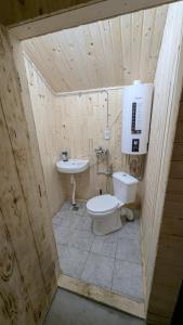 a wooden bathroom with a toilet and a sink at Байк Пост Т67 in Rakovo