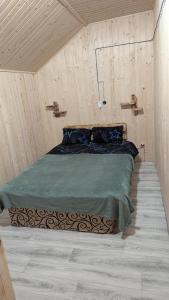 a bedroom with a bed in a wooden wall at Байк Пост Т67 in Rakovo