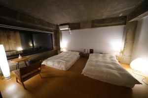 a large bedroom with two beds and a table at ALY HOTEL See Sea Son in Kure +6 photos