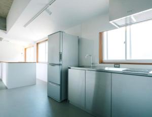 a kitchen with a stainless steel refrigerator in a room at ALY HOTEL See Sea Son in Kure