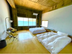 a bedroom with two beds and a table and a desk at ALY HOTEL See Sea Son in Kure